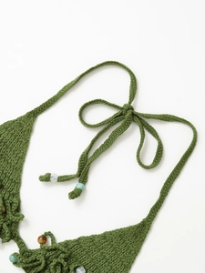 Detail of green knit halter top featuring exquisite hand-woven textures and wooden bead accents