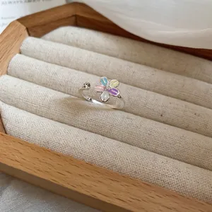 Bague fleur réglable avec pétales macaron et perles sur un coffret à bijoux beige