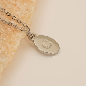 Polished silver stainless steel oval pendant with letter C on a thin cable chain