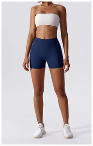 Detail of high-waist dark blue yoga shorts with breathable white crop top for women