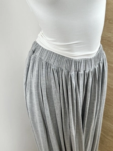 Detail of high-waist elastic waistband and pleated grey modal fabric with drape effect