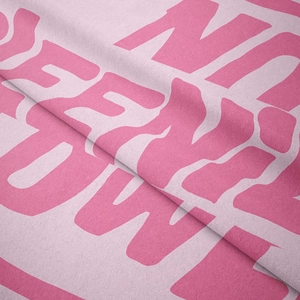 Close-up of soft pink microfiber fabric with artistic letter print and plush texture