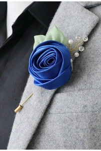 Detail of royal blue satin rose boutonniere on grey wool blazer for wedding