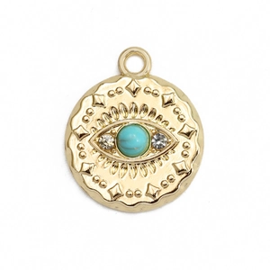 Detailed macro view of a gold evil eye charm with turquoise bead and white rhinestones