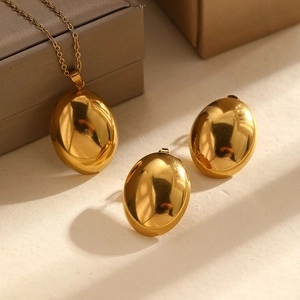 Polished gold jewelry set with oval pendant necklace and matching stud earrings on display