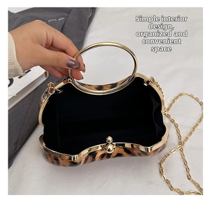 Macro shot of leopard print evening bag interior with gold chain strap and metal handle