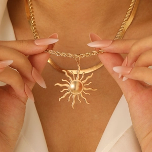 Nahaufnahme der goldenen Sonnenanhänger-Halskette mit dicker gedrehter Gliederkette