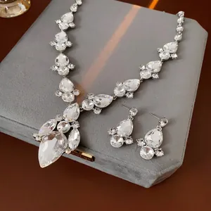 Set gioielli argento con cristalli a goccia su sfondo di velluto grigio