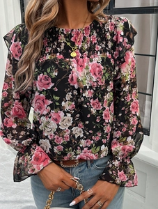 Detail of elegant black floral blouse with pink rose prints and ruffled elastic cuffs