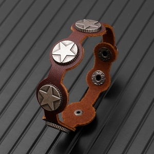 Macro detail of brown leather bracelet with star metal studs and adjustable snap buttons