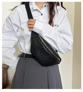 Détail du sac bandoulière tressé noir avec fermeture éclair dorée et motif à damier