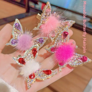 Detailed macro of moving butterfly hair clips with gold base and colorful rhinestones