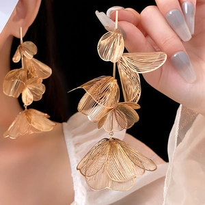 Detail of layered gold wire mesh floral earrings showing intricate petal texture