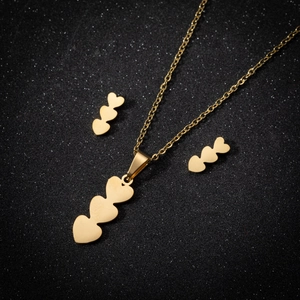 Golden heart necklace and earrings set with triple heart pendants on black background
