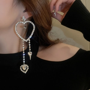 Close-up of heart tassel earrings with sparkling rhinestones on model with black outfit