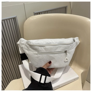 Detail of white corduroy waist bag featuring multiple zippers and nylon shoulder strap