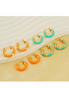 Detail of four titanium steel hoop earrings with orange and turquoise enamel inlay