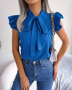 Detail of elegant royal blue sleeveless blouse with tie-bow neck and ruffled cuffs
