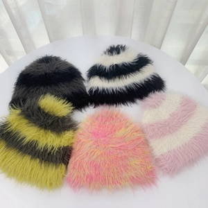 Plano detalle de gorros de punto con rayas de piel sintética en negro, gris, rosa y amarillo