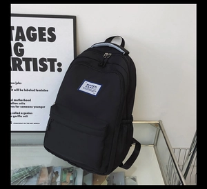 Detail view of the black Harajuku style backpack on a modern glass display stand