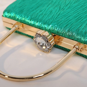 Elegant green pleated silk evening bag with gold metal handle and crystal flower clasp