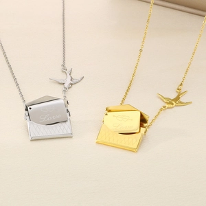 Détail de pendentifs enveloppes ouvrables en or et argent avec gravure Love sur collier