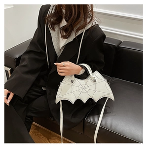 White bat wing handbag with spider web stitching shown in a lifestyle model setting