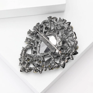 Close-up of alloy rhinestone brooch showing the vintage metal filigree and safety pin clasp
