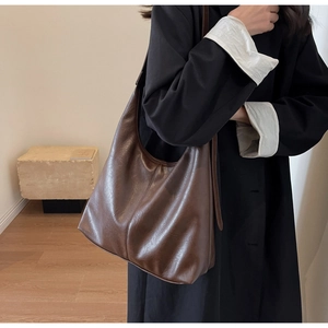 Deep brown soft leather hobo bag worn over shoulder for a casual commuter look