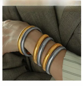 Close-up of dual-tone 10mm vintage striped titanium bracelets on woman's wrist