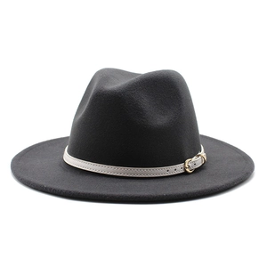 Detail of black wool fedora hat featuring a beige leather band with gold buckle accent