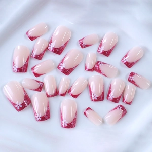 Pink French press-on nails with magenta glitter tips and white flower designs