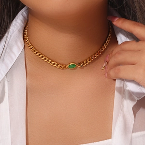 Detail of 18K gold-plated Cuban chain necklace featuring an oval green gemstone pendant