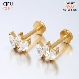 Détail du labret en titane G23 doré avec trois zircons blancs en marquise pour piercing