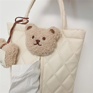 Close-up of quilted white PU leather car tissue box cover with cute brown bear embroidery