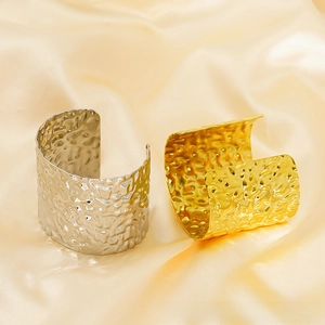 Detail view of gold and silver cuff bracelets with premium hammered metal texture finish