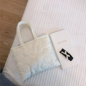 Dettaglio ravvicinato di una borsa a mano trapuntata bianca con ricamo floreale