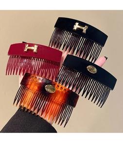 Detail view of retro acrylic hair combs with golden H-shaped and round metal buckles