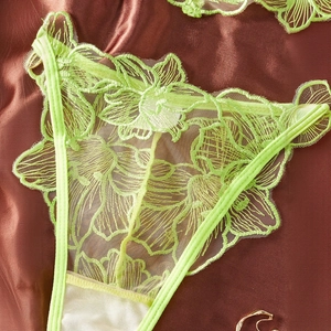 Detailed macro view of fluorescent green lace embroidery panties with floral textures