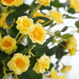 Artificial yellow rose bouquet for home decoration with green leaves in close-up view