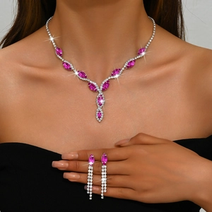 Detailed view of bride jewelry set featuring fuchsia marquise crystals and tassel earrings