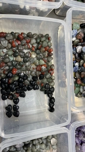 Macro view of assorted 15mm heart-shaped quartz stones in black and green mixed colors