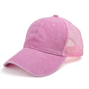 Detailed side view of washed cotton mesh trucker hat in vibrant pink with breathable back