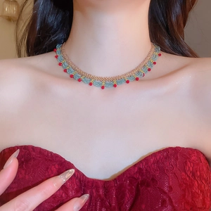 Detailed view of handmade beaded choker with gold, teal, and red beads on a model's neck