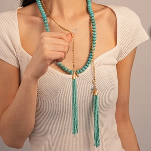 Long collier bohème en perles turquoise avec chaîne dorée et pompons élégants