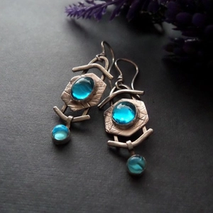 Boucles d'oreilles vintage en argent avec pierre de lune bleue sur fond texturé