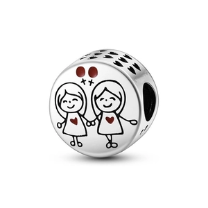 Macro shot of silver cylinder charm with two girls engraving and red enamel heart detail