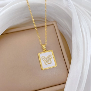Macro shot of gold butterfly pendant with mother of pearl shell and crystals on jewelry box