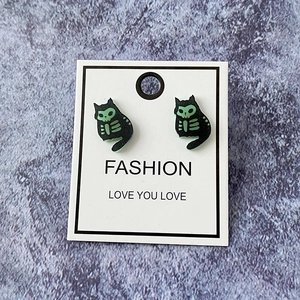 Detailed view of Halloween ghost cat earrings with green glow-in-the-dark skeleton pattern