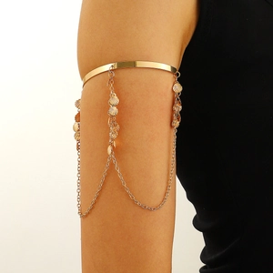 Gold upper arm bracelet with hanging chains and seashell charms in bohemian style